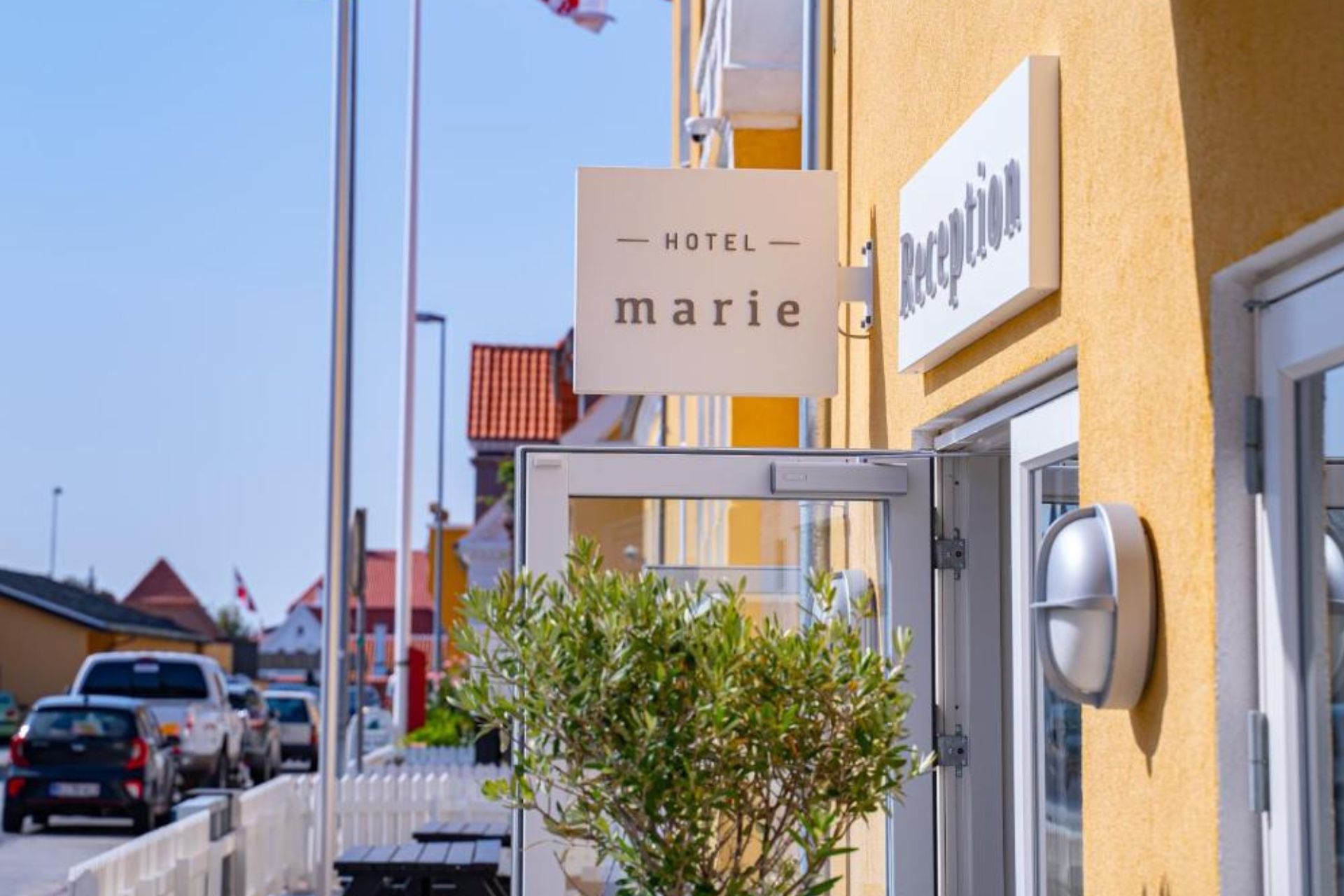 En solbeskinnet indgang til Hotel Marie i den klassiske skagengule farve. Foto: PR